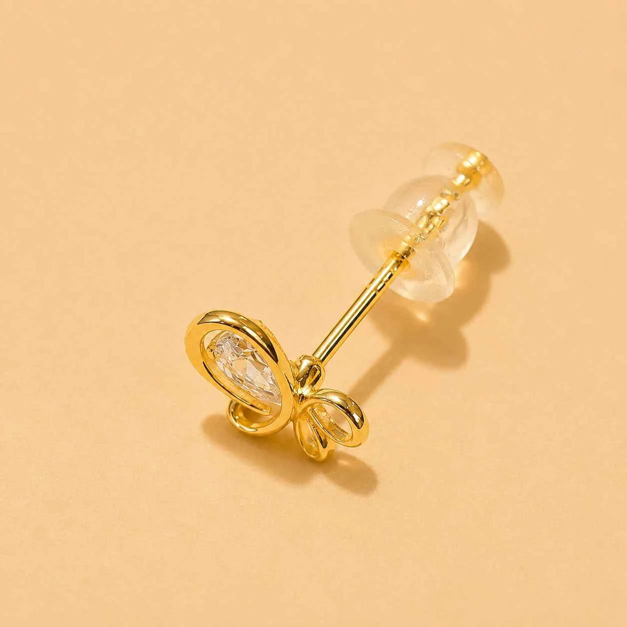 Butterfly stud earring close-up with gold-tone wings and clear crystal center.
