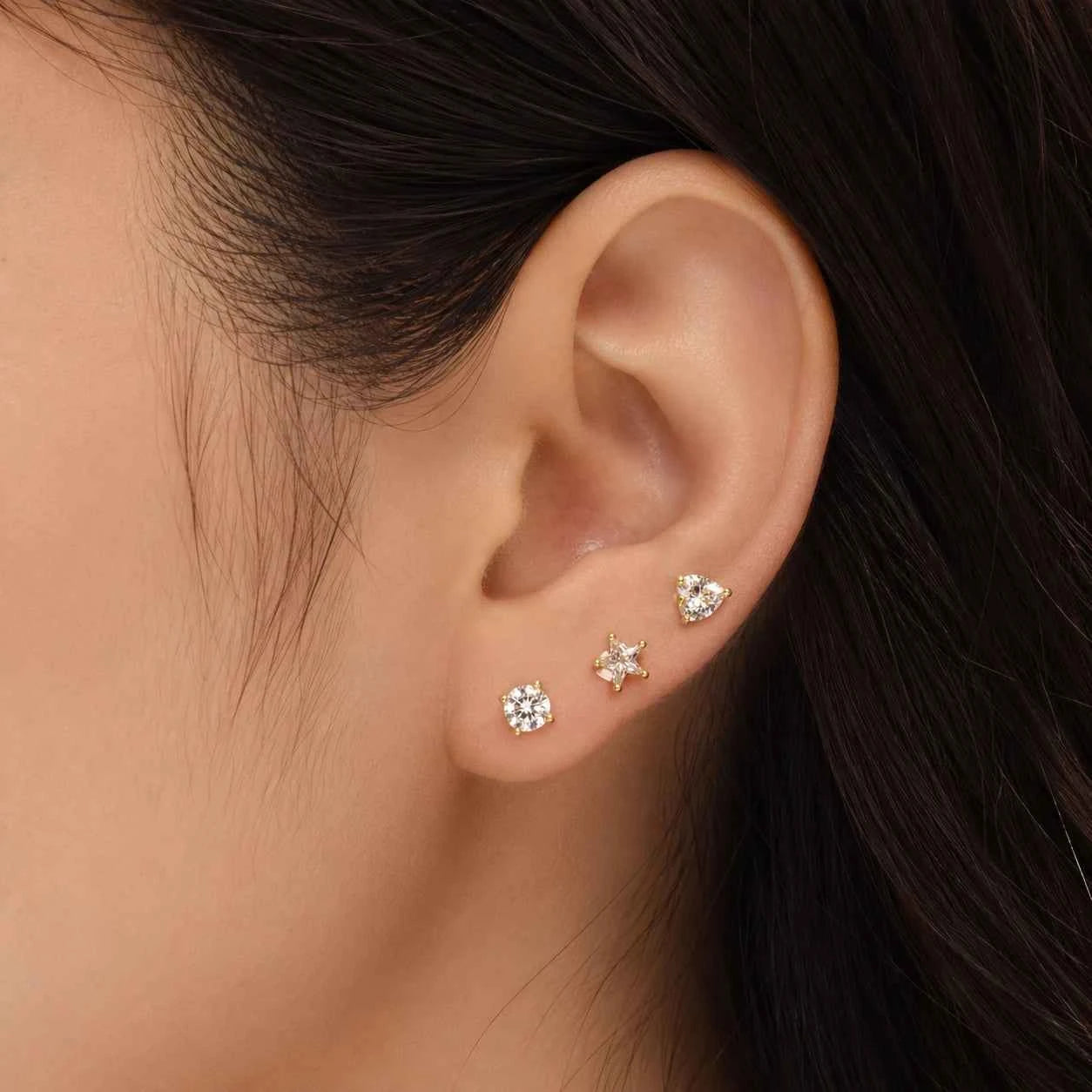 Butterfly stud earrings on ear, gold-tone with clear crystal sparkle stones