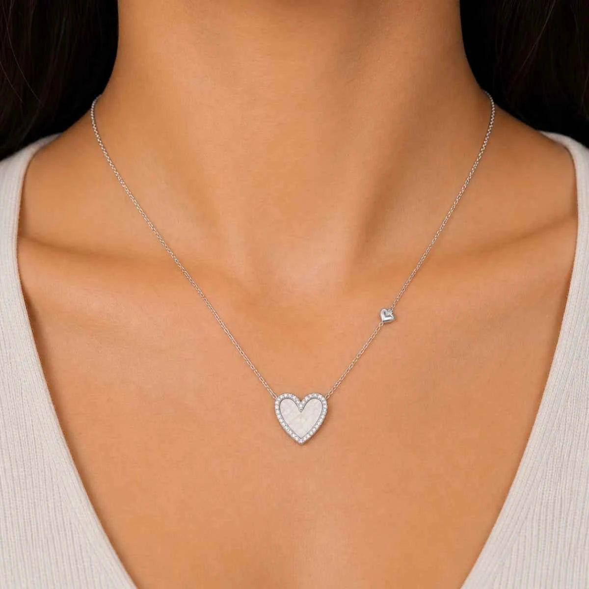 925 silver heart pendant necklace worn on model with small heart charm above