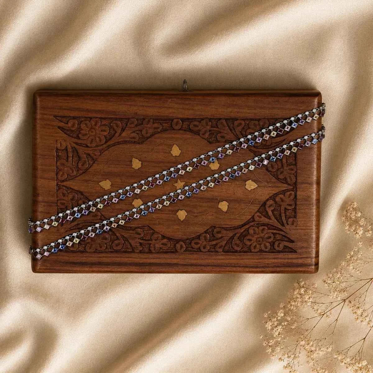 Silver beaded bracelet on patterned wooden display box