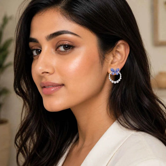 Butterfly halo stud earrings with blue butterfly and pearl-like hoop on a model