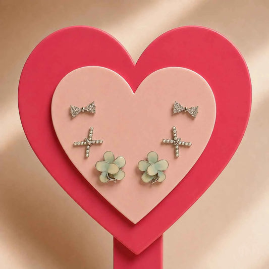 Stud earrings set with bow, cross, and flower CZ studs shown in heart layout