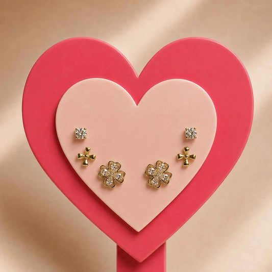 Gold-tone clover stud earrings set with four-leaf motifs, on heart display
