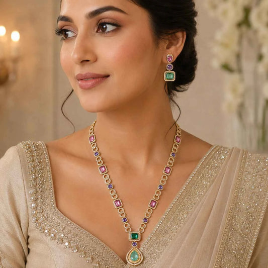 Gold-tone multicolor gemstone necklace set with square and teardrop pendants, worn at neckline