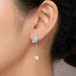 Silver butterfly earring with pearl drop worn by a person