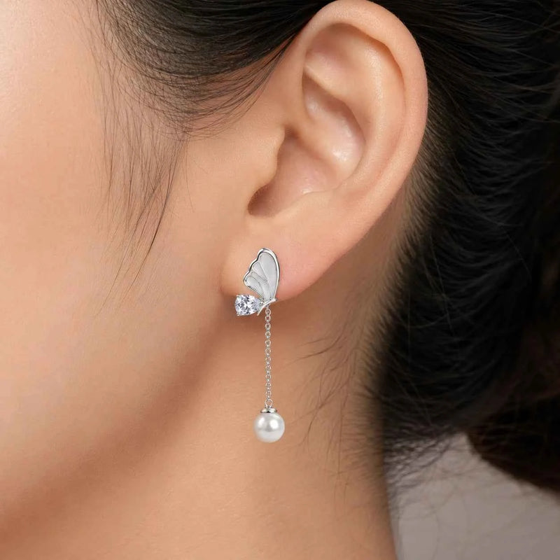 Silver butterfly drop earrings with pearl bead dangling from thin chain