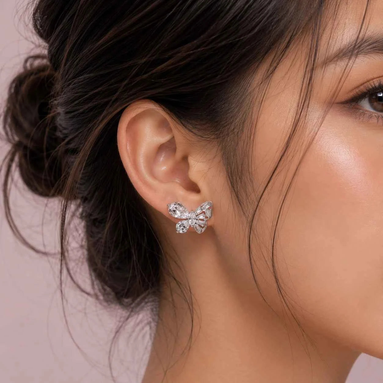 Butterfly stud earrings in 925 silver on ear, with crystal bow detail