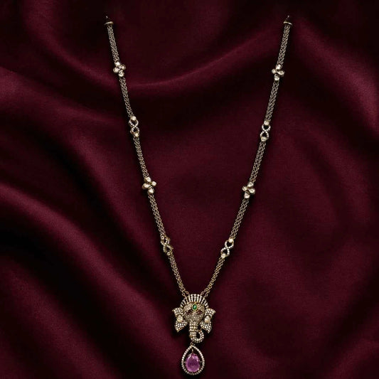 Ganesha pendant necklace set with ornate elephant face pendant and purple oval drop