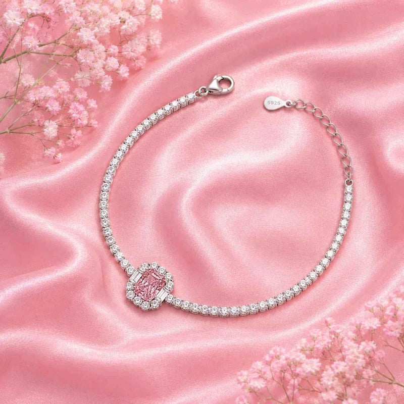Silver tennis bracelet with pink round center stone and chain clasp