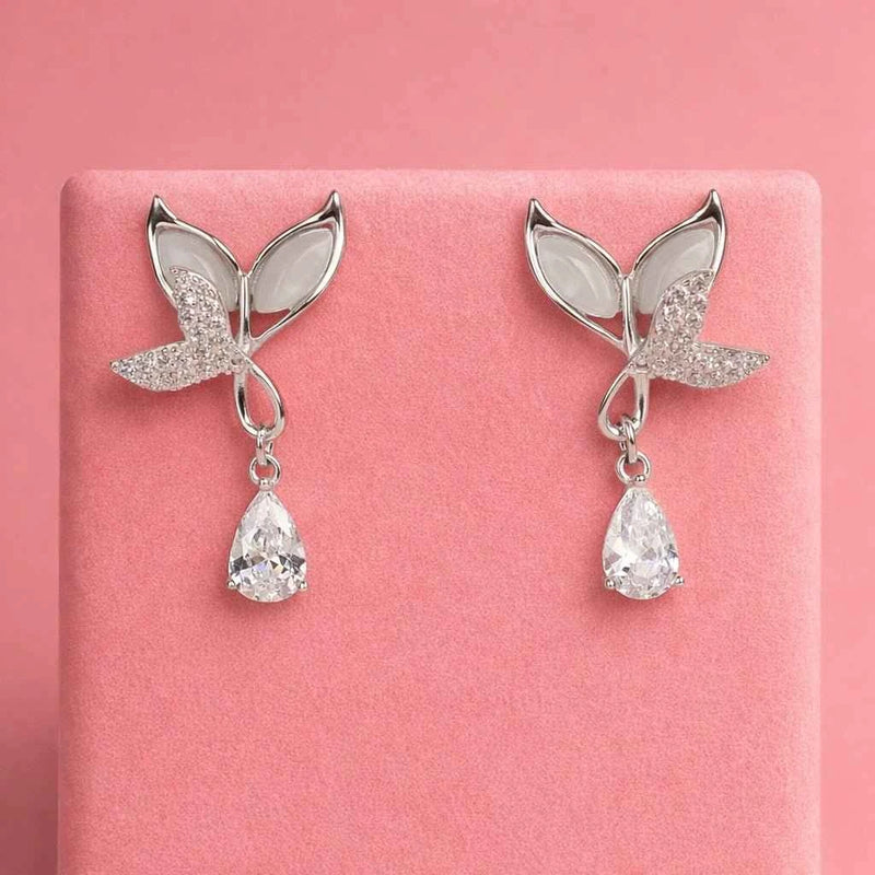 Pair of silver butterfly wing drop earrings with textured wings and teardrop crystal pendants