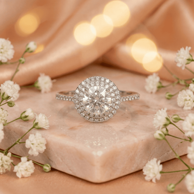 Silver halo solitaire ring with round center stone and pavé band, prong set