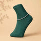 Silver 925 anklet pair with sparkling chain detail on green sock