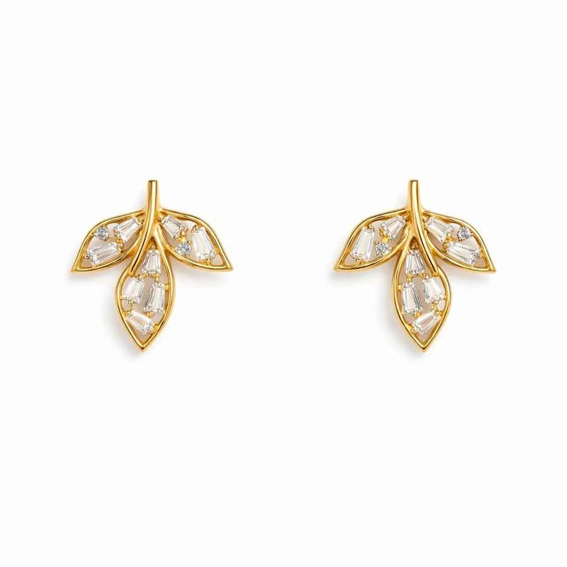 Gold-tone leaf stud earrings with clear baguette stones, pair on white background