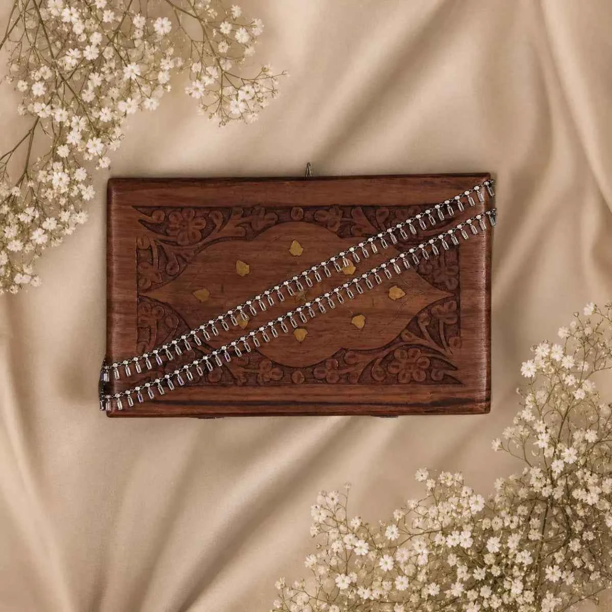 925 silver chain bracelet with dangling charm on a rectangular wooden display tray