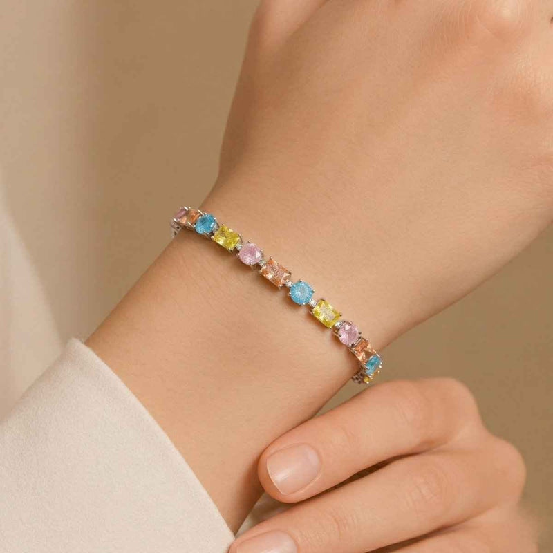 925 silver tennis bracelet on wrist with pastel halo links and blue yellow pink stones