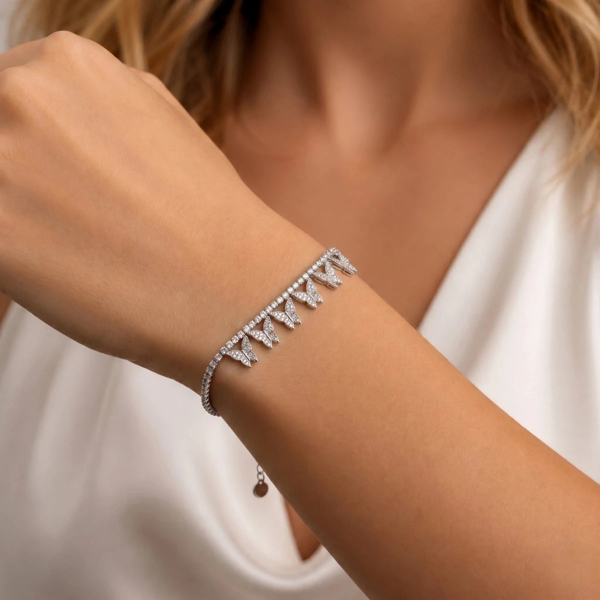 CZ butterfly link bracelet on wrist, silver band with repeating sparkly links
