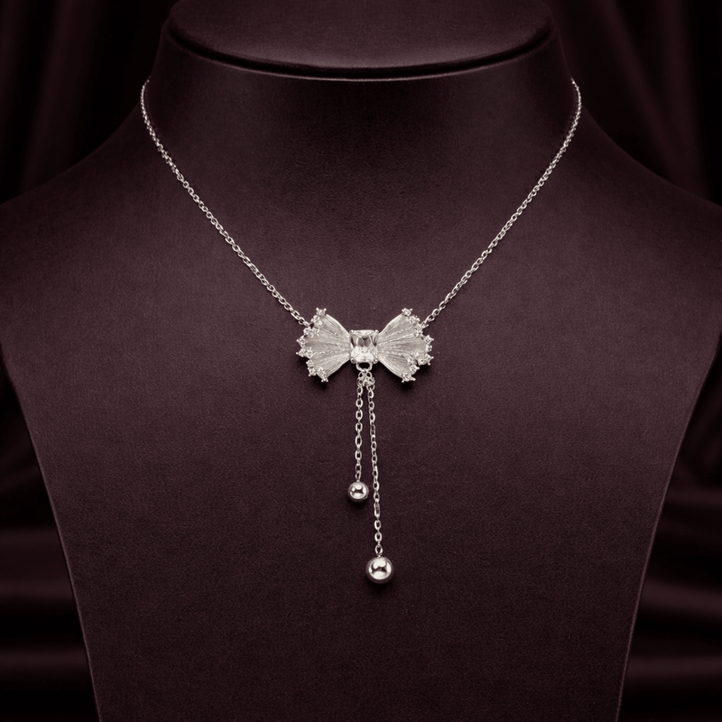 925 silver bow drop necklace with textured bow center and two hanging bead charms