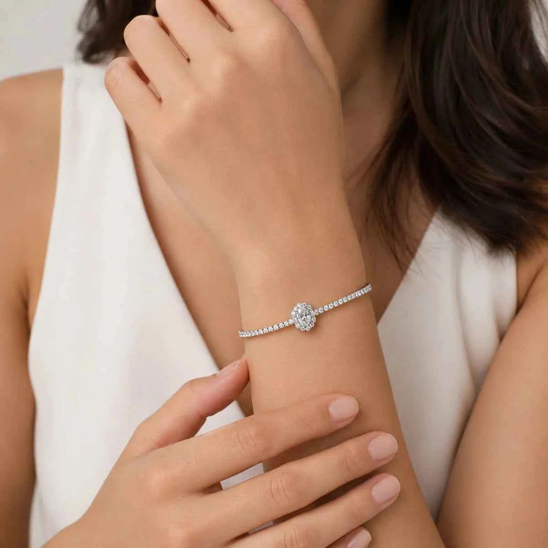 Silver oval solitaire bracelet on wrist, with round pavé center stone and chain